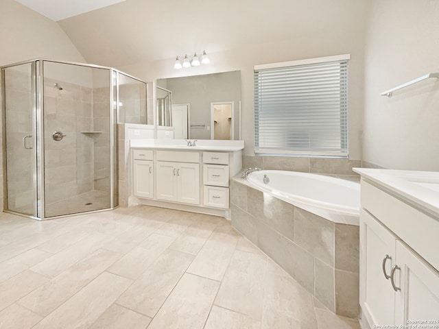 bathroom with tile patterned flooring, vanity, lofted ceiling, and independent shower and bath