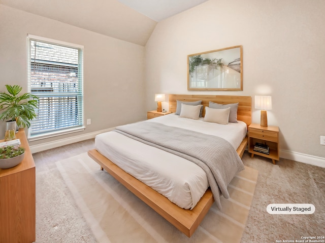 bedroom featuring light colored carpet and lofted ceiling