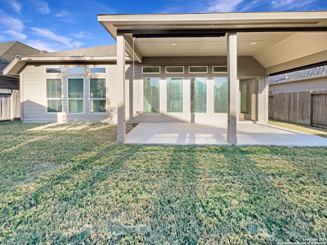 back of property featuring a lawn and a patio area