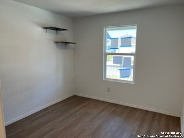 empty room with dark hardwood / wood-style flooring