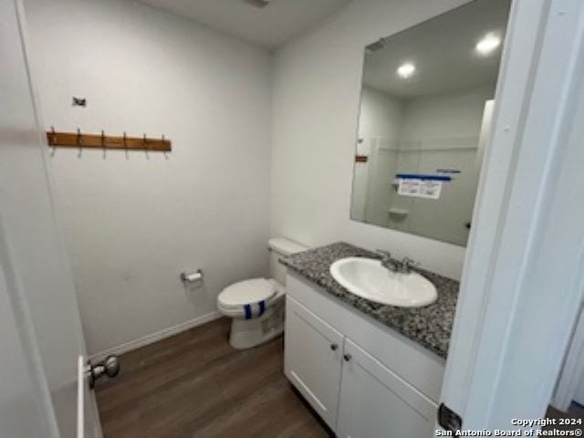 bathroom featuring hardwood / wood-style floors, vanity, and toilet