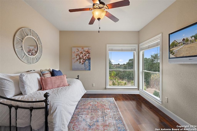 bedroom with dark hardwood / wood-style floors and ceiling fan