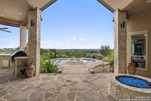 view of patio with area for grilling and a pool with hot tub