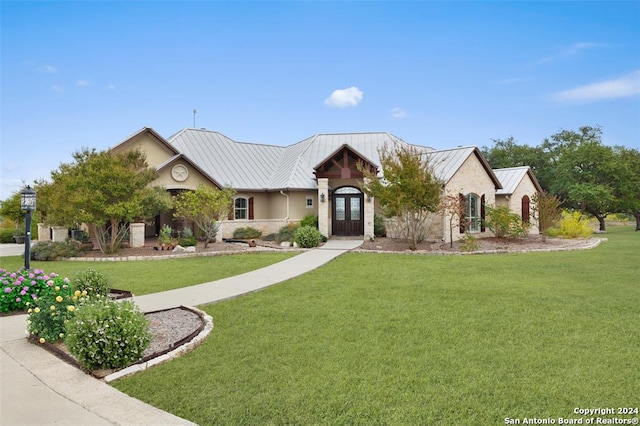 view of front of home with french doors and a front lawn