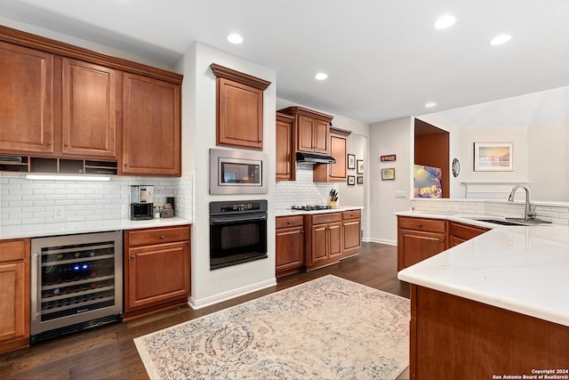 kitchen with dark hardwood / wood-style flooring, stainless steel microwave, oven, and beverage cooler