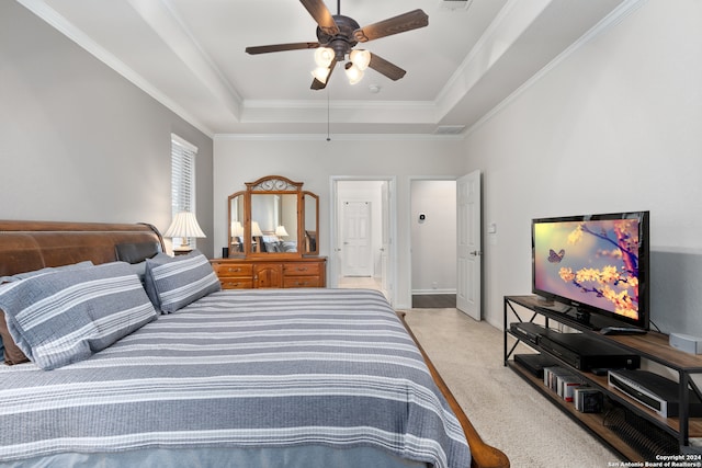 carpeted bedroom featuring ceiling fan, ornamental molding, and a tray ceiling