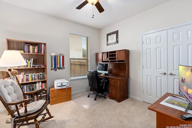 carpeted home office featuring ceiling fan