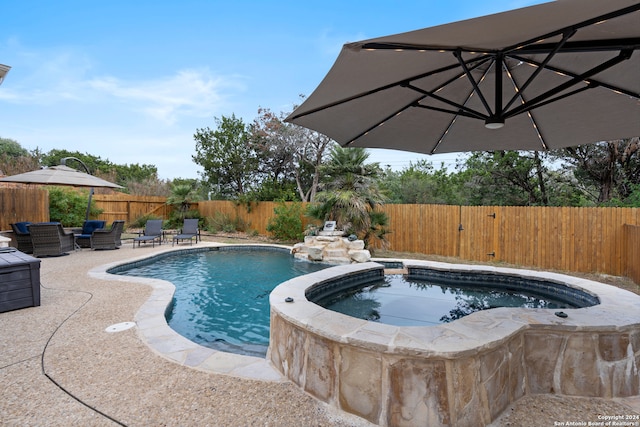 view of pool with a patio area and an in ground hot tub