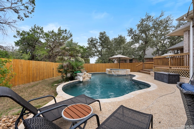 view of swimming pool featuring a patio, an in ground hot tub, and a wooden deck