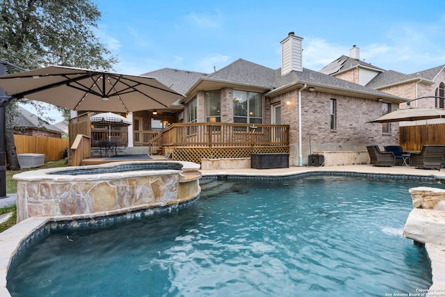 view of swimming pool featuring an in ground hot tub and a deck