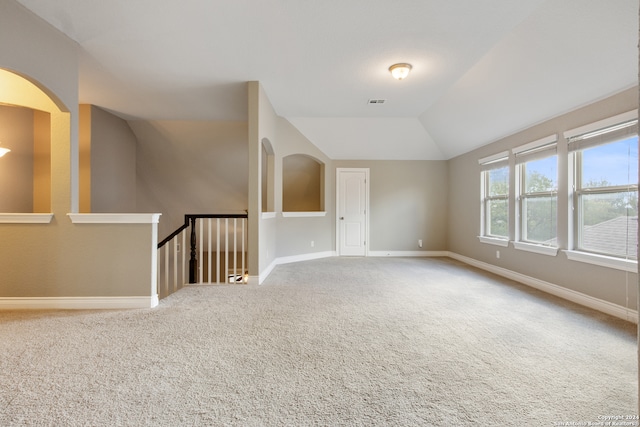 spare room with carpet flooring and vaulted ceiling