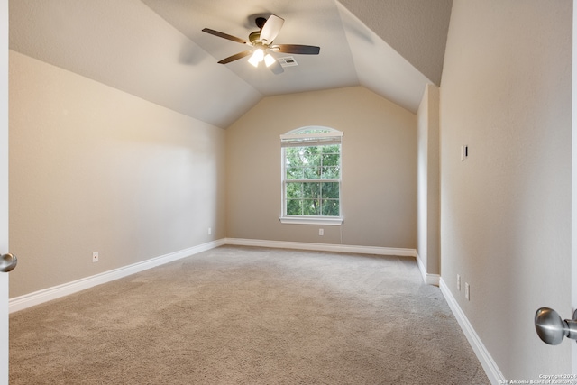 empty room featuring ceiling fan, light colored carpet, and lofted ceiling