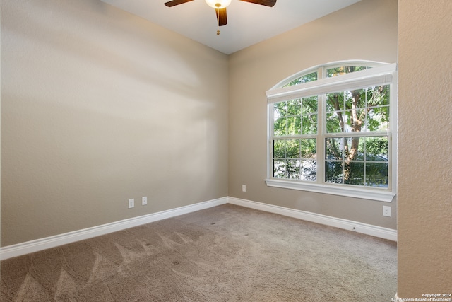 carpeted spare room with ceiling fan