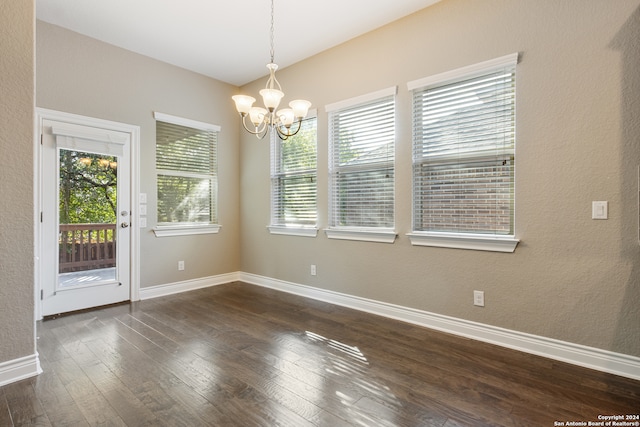 unfurnished dining area featuring dark hardwood / wood-style flooring and a chandelier