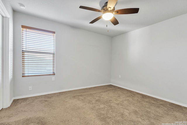 carpeted spare room featuring ceiling fan