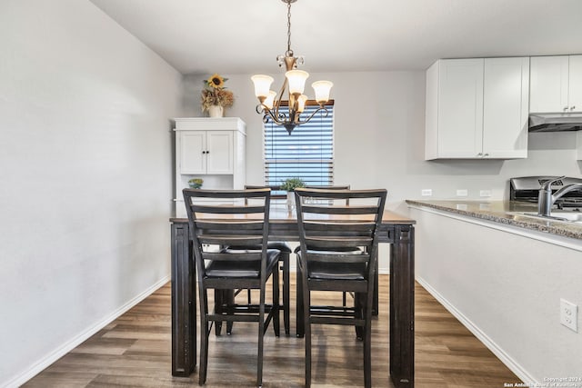 dining space featuring dark hardwood / wood-style floors, a chandelier, and sink