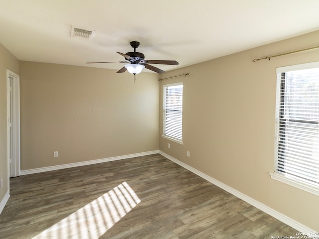 unfurnished room with dark hardwood / wood-style floors and ceiling fan