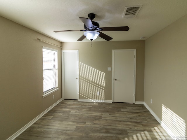 unfurnished room featuring hardwood / wood-style flooring, ceiling fan, and a textured ceiling