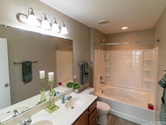 full bathroom with vanity, hardwood / wood-style flooring, toilet, a textured ceiling, and tub / shower combination