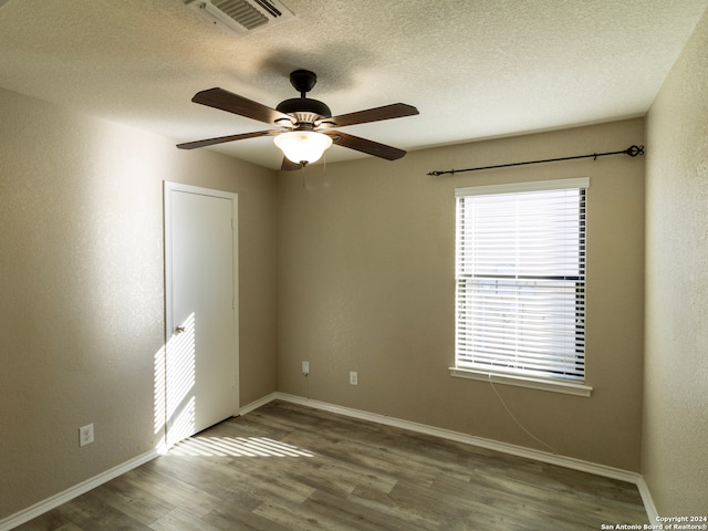 spare room featuring hardwood / wood-style floors, ceiling fan, and a textured ceiling