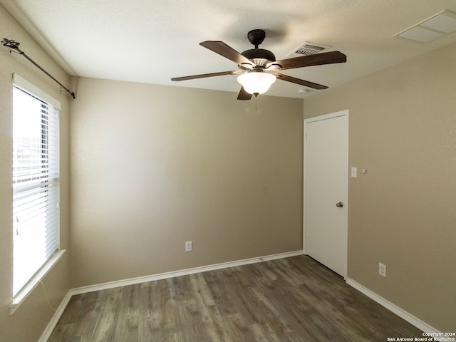 unfurnished room with dark hardwood / wood-style floors and ceiling fan