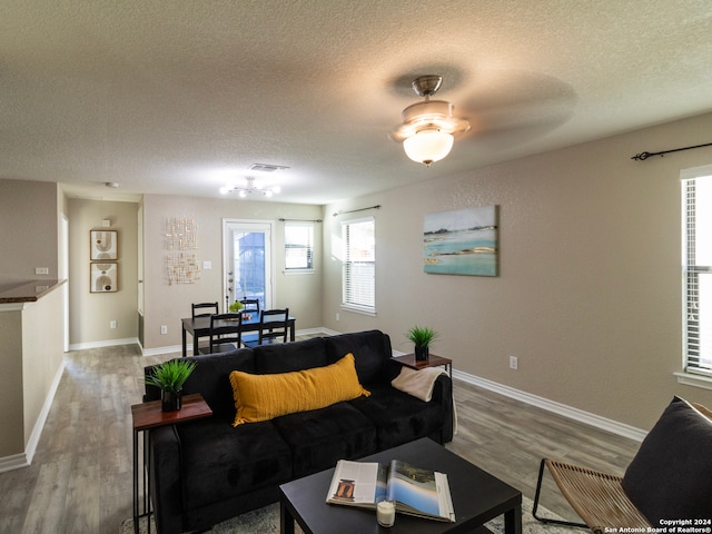 living room with a textured ceiling, hardwood / wood-style flooring, and ceiling fan