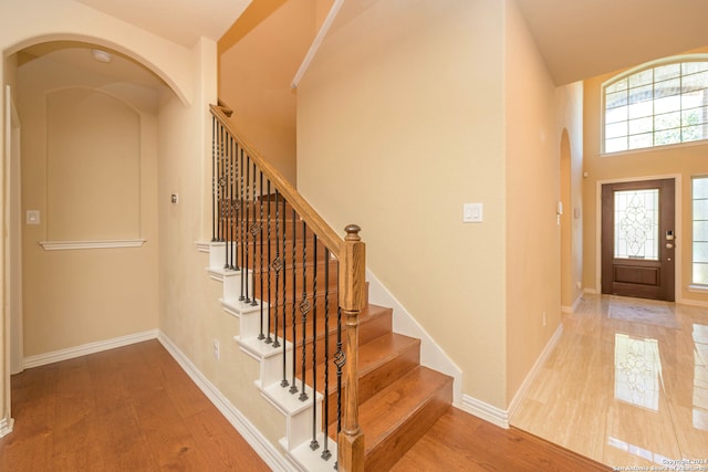 entryway featuring wood-type flooring and a high ceiling