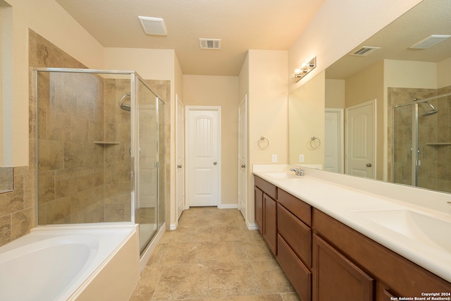 bathroom with vanity, a textured ceiling, and shower with separate bathtub