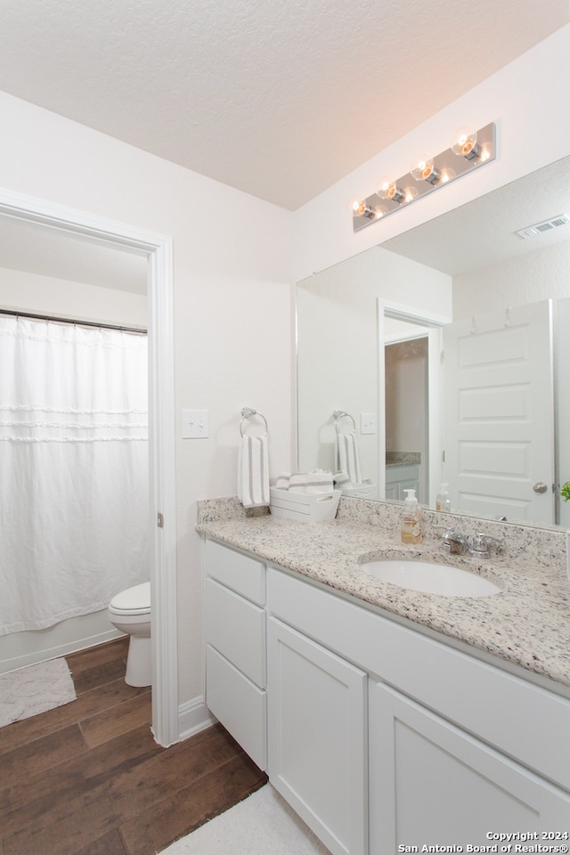 bathroom with vanity, wood-type flooring, and toilet