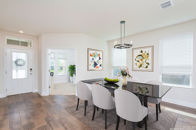 dining room with dark hardwood / wood-style flooring and a chandelier