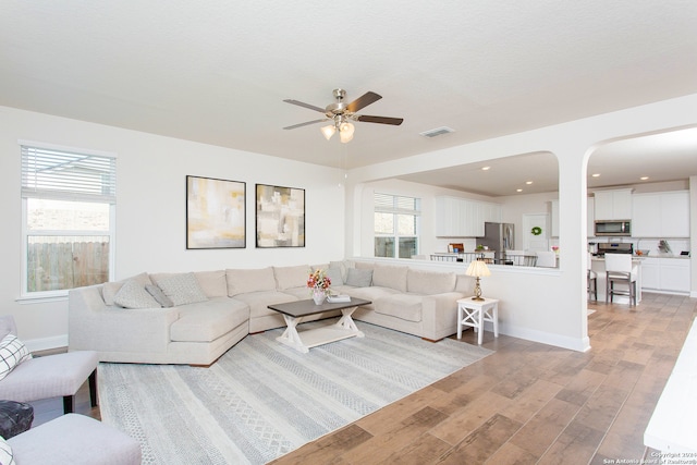 living room featuring ceiling fan and light hardwood / wood-style flooring