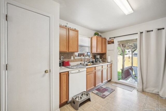 kitchen featuring backsplash, dishwasher, and sink