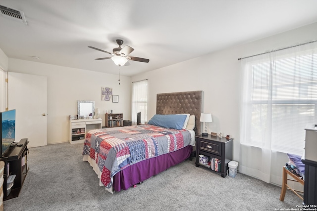 carpeted bedroom featuring multiple windows and ceiling fan