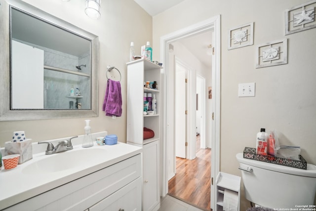 bathroom featuring toilet, vanity, a shower with shower door, and hardwood / wood-style flooring