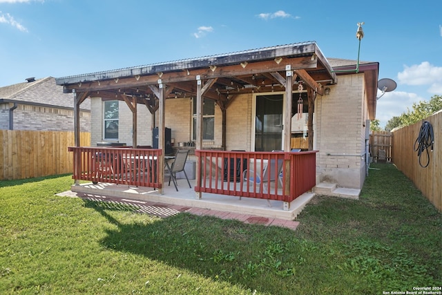 rear view of property featuring a yard and a patio area