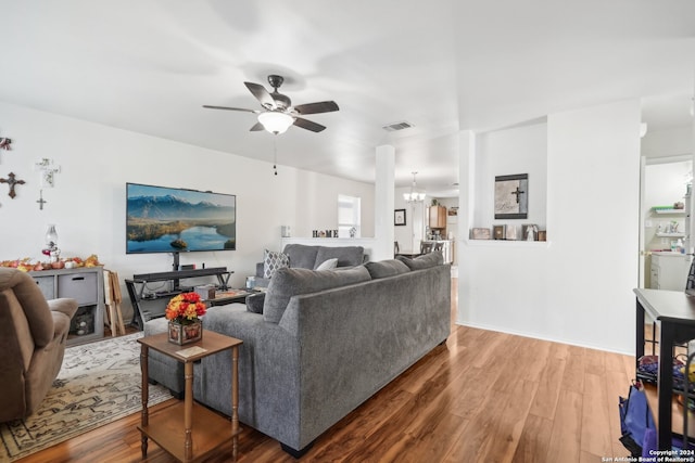 living room featuring hardwood / wood-style floors and ceiling fan with notable chandelier