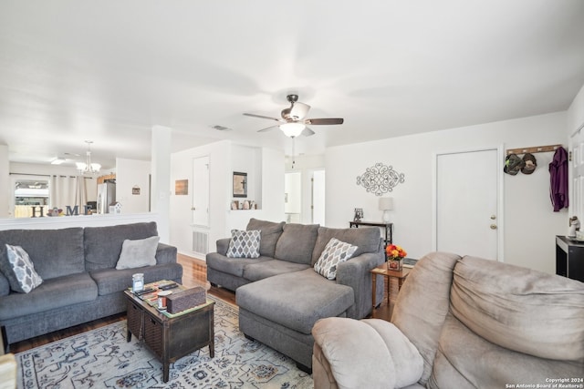 living room featuring light hardwood / wood-style floors and ceiling fan with notable chandelier