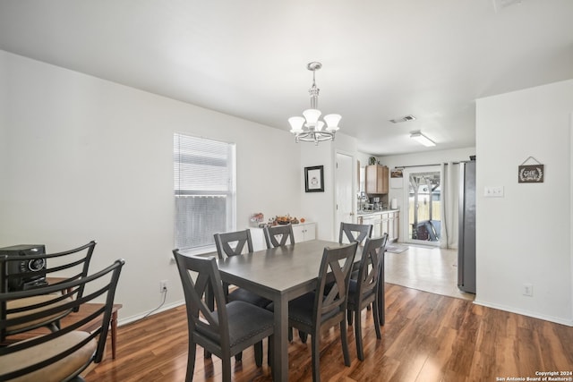 dining area featuring dark hardwood / wood-style flooring and an inviting chandelier