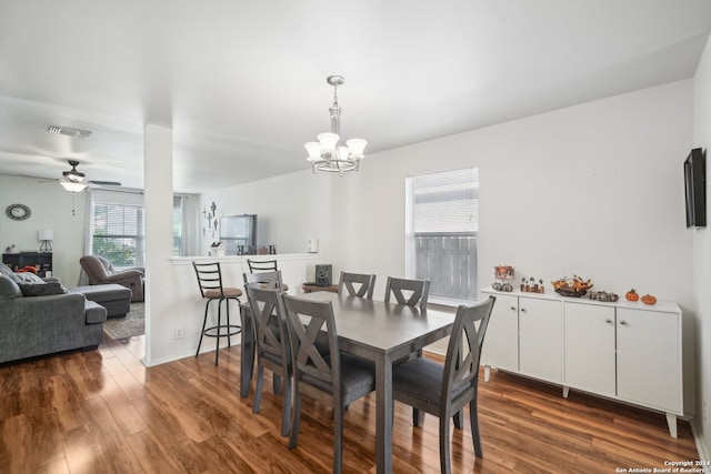 dining area featuring ceiling fan with notable chandelier and wood-type flooring