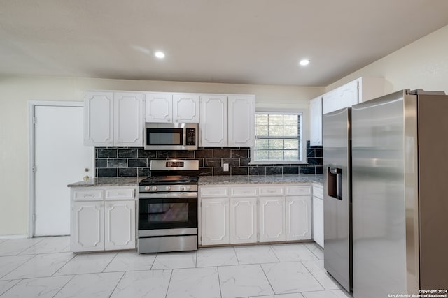 kitchen featuring white cabinets, decorative backsplash, and appliances with stainless steel finishes