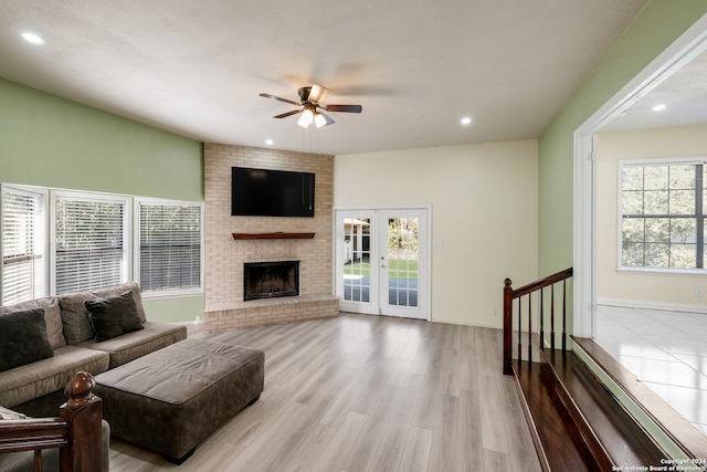 living room featuring ceiling fan, a healthy amount of sunlight, french doors, and light hardwood / wood-style flooring