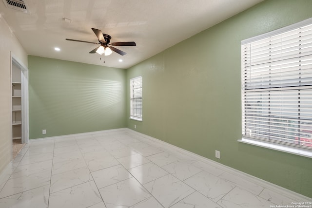 empty room featuring ceiling fan and a healthy amount of sunlight