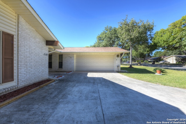 view of property exterior with a lawn and a garage