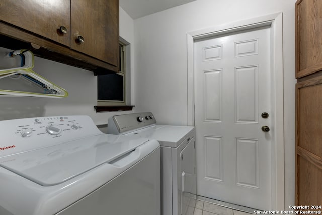 washroom with cabinets, washer and clothes dryer, and light tile patterned flooring