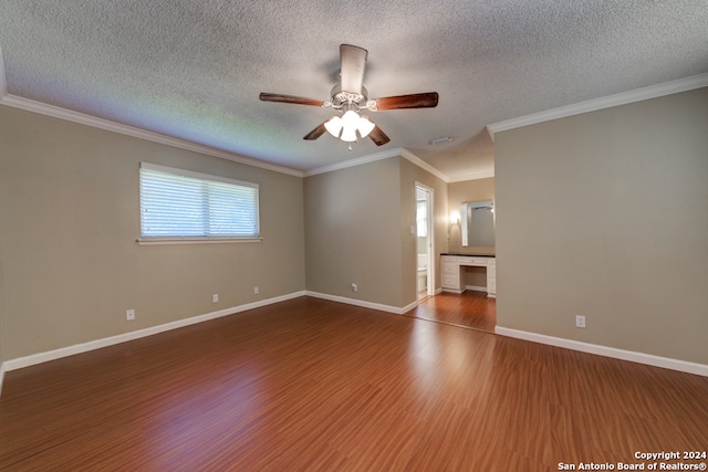 unfurnished living room featuring crown molding, hardwood / wood-style flooring, ceiling fan, built in desk, and a textured ceiling