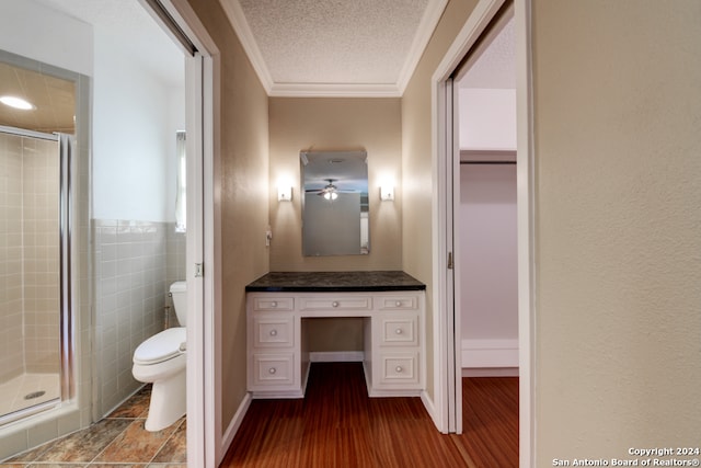 bathroom with a shower with door, hardwood / wood-style flooring, toilet, ornamental molding, and a textured ceiling