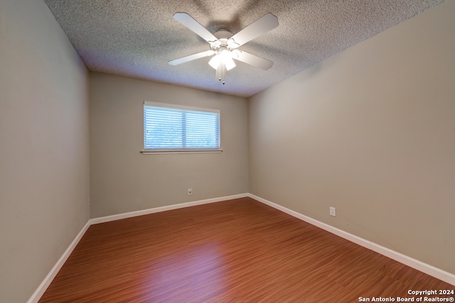 spare room with ceiling fan, wood-type flooring, and a textured ceiling