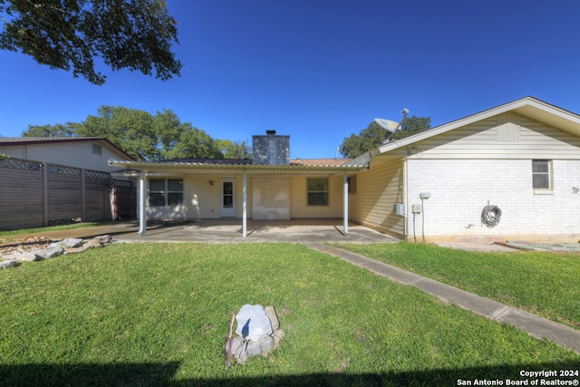 rear view of property with a yard and a patio