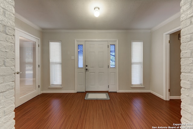 entrance foyer featuring a textured ceiling, dark hardwood / wood-style flooring, and crown molding