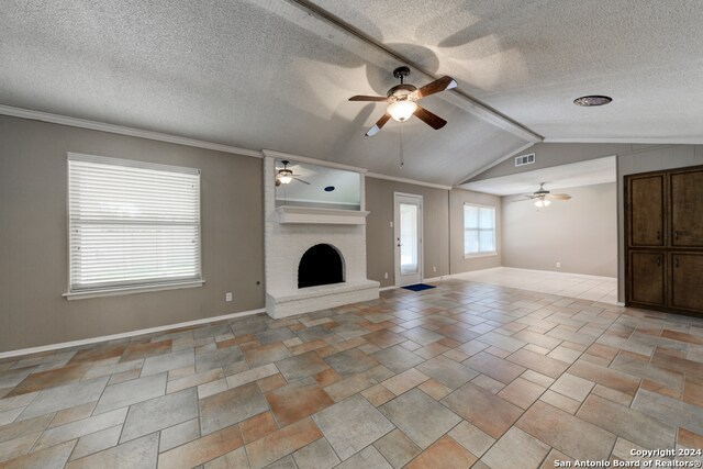 unfurnished living room with ceiling fan, a brick fireplace, crown molding, vaulted ceiling, and a textured ceiling